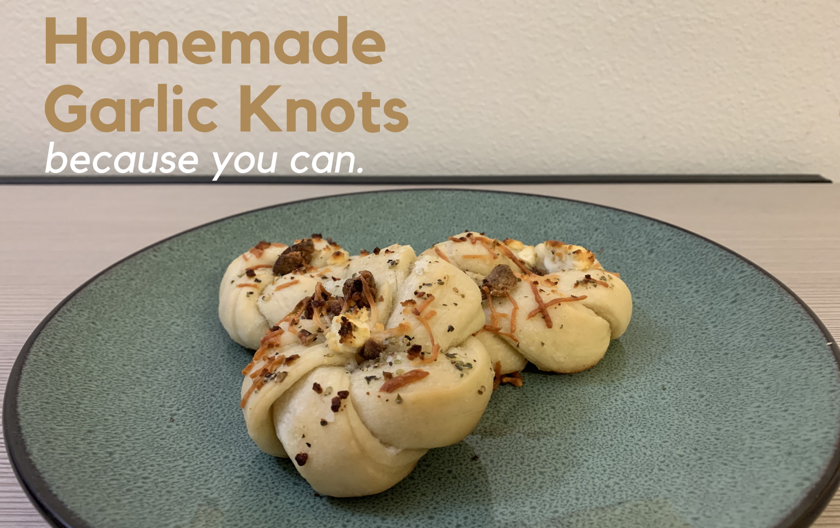 Homemade garlic knots written in the top left corner with 3 garlic knots in the center on a gray plate